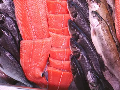 Lachs- und Kabeljaufilets neben ganzen Fischen in der Auslage