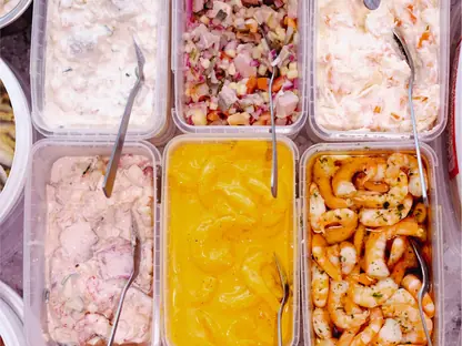 Viele Sorten Fischsalat in Edelstahlschalen in der Auslage