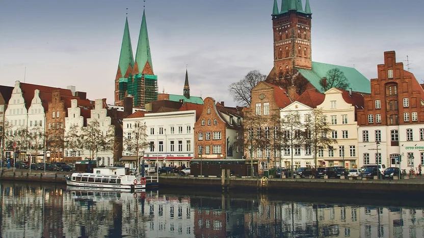 Lübecks Uferzeile an der Trave mit Giebelhäusern, dahinter die Türme von Marienkirche und Petrikirche
